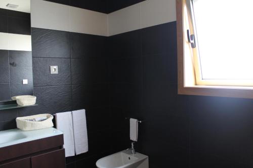 a black bathroom with a toilet and a window at Casal da Porta - Quinta da Porta in Mirandela