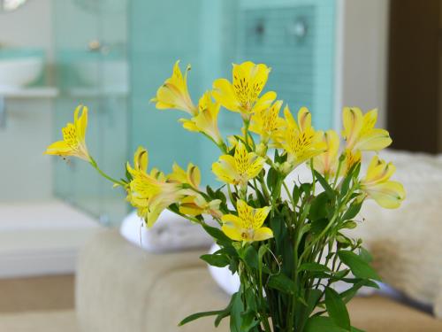 a bouquet of yellow flowers in a vase at 3 On Camps Bay in Cape Town