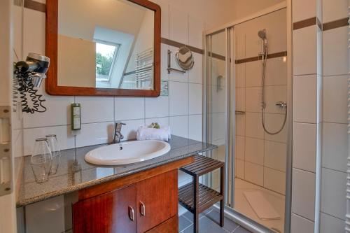 ein Bad mit einem Waschbecken und einer Dusche in der Unterkunft Hotel Worpsweder Tor in Worpswede