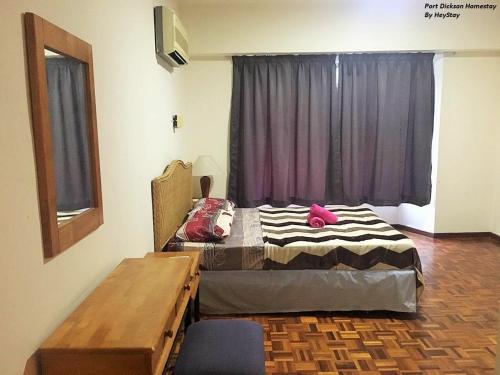 Schlafzimmer mit einem Bett, einem Tisch und einem Fenster in der Unterkunft 6-8pax Cozy Homestay @ Teluk Kemang Port Dickson in Port Dickson