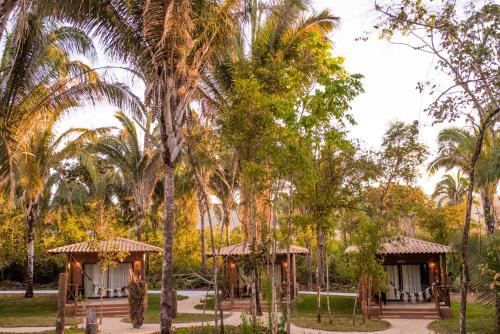 a resort with palm trees and two gazebos at Pousada Aldeia da Serra in Palmas