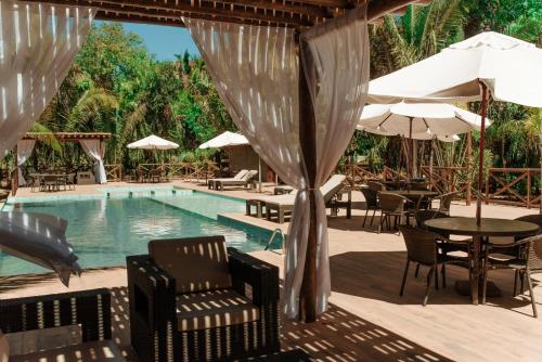 a pool with chairs and tables and umbrellas at Pousada Aldeia da Serra in Palmas