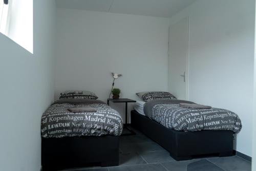 dos camas sentadas una al lado de la otra en un dormitorio en Huis van Harderwijk, en Harderwijk