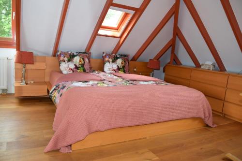 a bedroom with a bed with a pink blanket at B&B Kamperfoelie in Gorssel