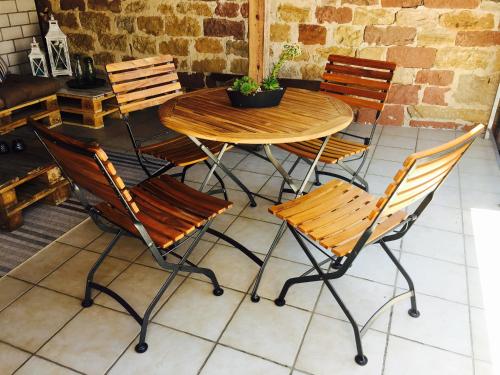 a wooden table and chairs with a plant on it at Gästehaus Sellemols Ferienhaus Winzer in Heuchelheim-Klingen