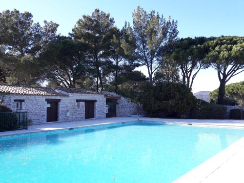 - une piscine en face d'une maison en pierre dans l'établissement JOLI MAZET ST TROPEZ, à Gassin