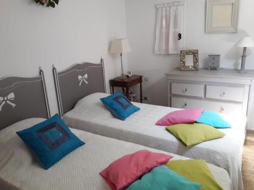 2 łóżka z kolorowymi poduszkami w sypialni w obiekcie JOLI MAZET ST TROPEZ w mieście Gassin