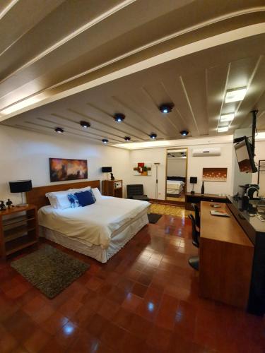 a bedroom with a bed and a desk and a television at Casa dos Meninos B&B in Ouro Preto