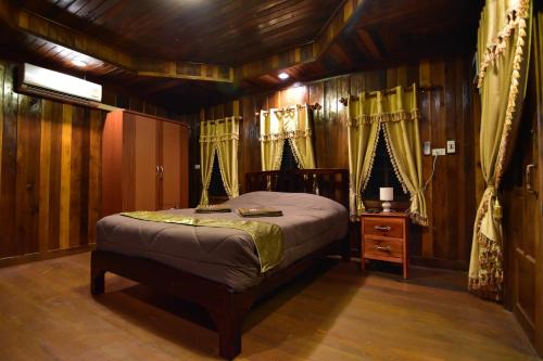 a bedroom with a bed in a room with wooden walls at Linda's Place in Rayong