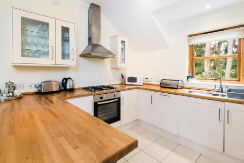 a kitchen with white cabinets and a wooden counter top at The Atholl Palace in Pitlochry