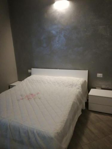 a bedroom with a white bed and two night stands at Affittacamere New Lifestyle in Alberoro