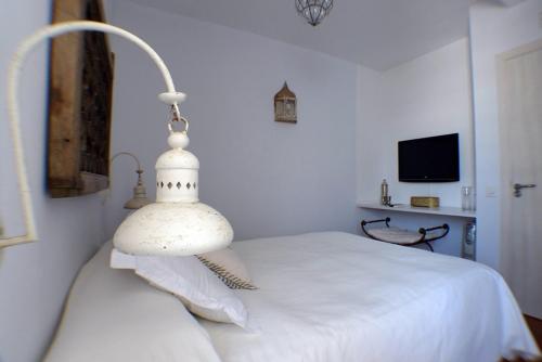 a bedroom with a white bed with a lamp at Benali Guest House in Tarifa