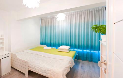 Un dormitorio con una cama y una cortina azul. en CosmopolitApart, en Sibiu
