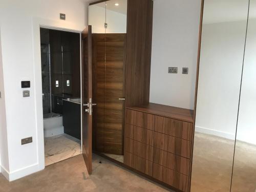 a bathroom with a wooden closet with a mirror at Birchover One The Brayford in Lincoln