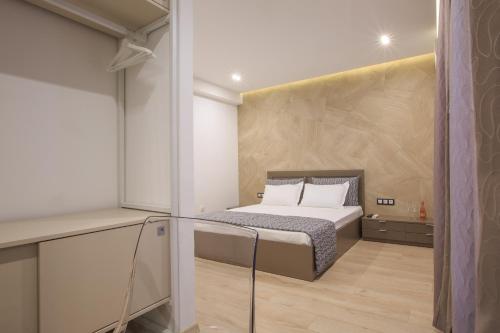 um pequeno quarto com uma cama e uma mesa de vidro em South Place Apartments em Sandanski