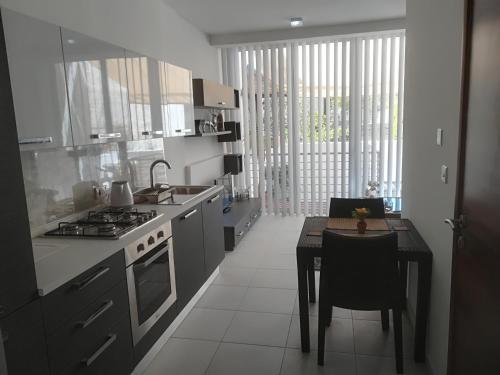a kitchen with a stove and a table with a dining room at Luxury Apartment close to seafront in Sliema