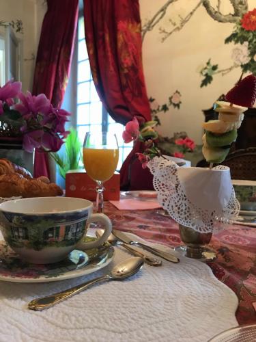 a table with a cup of coffee and a plate of food at La Rebière d'Or, B&B et Gîte in Mouleydier