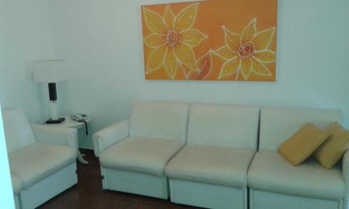 a living room with a couch and a chair at Residencial flat Golden beach.. in Guarujá
