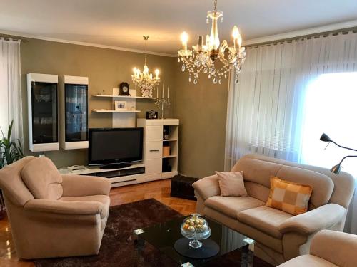 un soggiorno con 2 sedie e una TV di Apartments Dreams Centar a Živinice