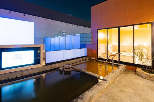 uma piscina de água num edifício com uma tv em U-Neru em Narashino