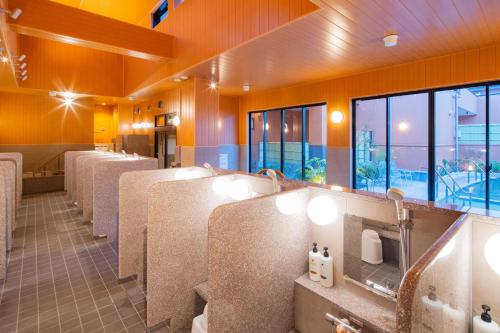 a public restroom with a row of sinks and mirrors at U-Neru in Narashino