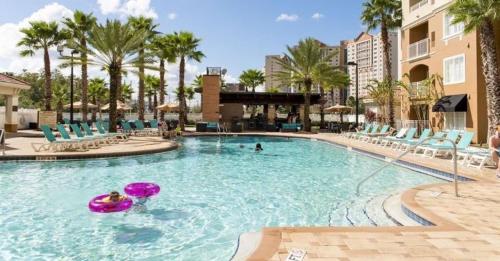 a large swimming pool with chairs and a frisbee in it at The Point Hotel & Suites - 705S Luxury - Pool view - Close to Universal in Orlando