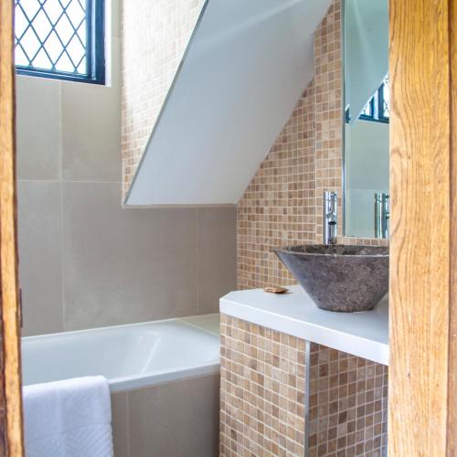 a bathroom with a sink and a bath tub at Great Fosters - Near Windsor in Egham
