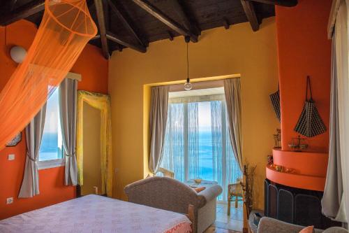 een slaapkamer met oranje muren en een bed en een raam bij Villa Matula in Kalamitsi