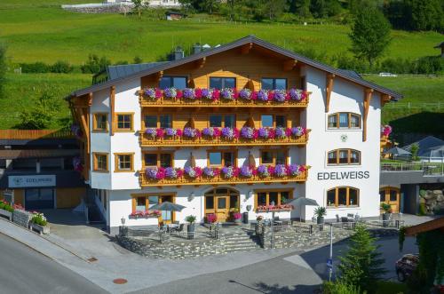 a building with flowers on the balconies of it at Pension Edelweiß in Sankt Johann im Pongau