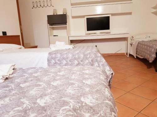 a hotel room with two beds and a flat screen tv at SPIEDO IMPERIALE - Locanda e Ristorante in Cotignola