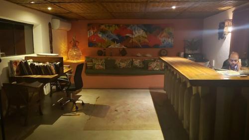 a man sitting at a desk in a room with a bar at Pousada e Mergulho Jamanta in Angra dos Reis