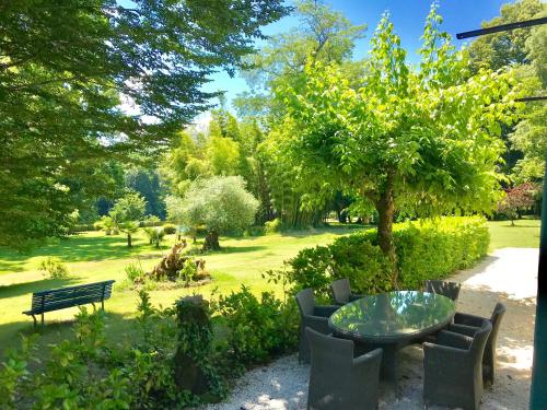 a park with a table and chairs and a tree at La Rebière d'Or, B&B et Gîte in Mouleydier