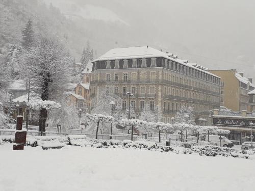 une ville enneigée avec un grand bâtiment dans l'établissement Appt de charme T3 50m2 hypercentre Cauterets, à Cauterets