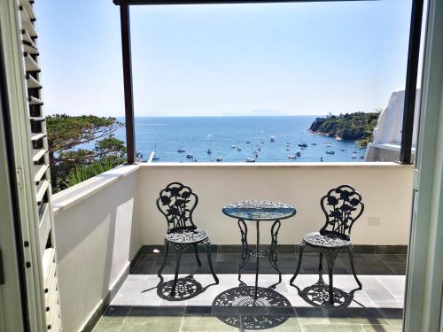 een balkon met 2 stoelen en een tafel en de oceaan bij Calise Guest house in Procida