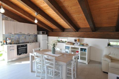 una cucina con soffitto in legno, tavolo e sedie di B&B Cascina Fiorita a Santa Maria La Carità