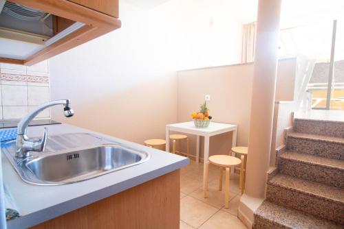 a kitchen with a sink and a staircase at Apartamentos Punta Marina by LIVVO in Morro del Jable