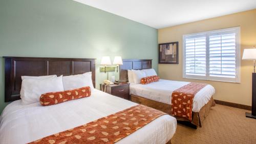 a hotel room with two beds and a window at staySky Suites I-Drive Orlando Near Universal in Orlando