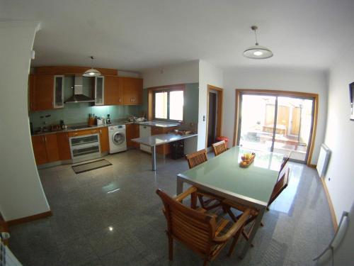 a kitchen and dining room with a table and chairs at Cabedelo guest house in Viana do Castelo