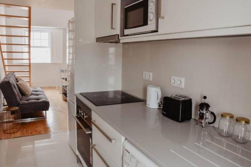a kitchen with a counter top with a microwave at T1 central e calmo, moderno e acolhedor em Coimbra - Self check in in Coimbra