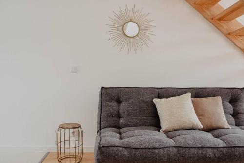 a couch in a living room with a mirror on the wall at T1 central e calmo, moderno e acolhedor em Coimbra - Self check in in Coimbra