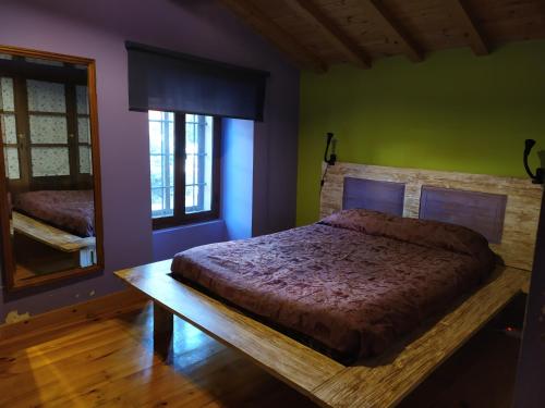 1 dormitorio con cama y espejo. en Casa Almenara, en Almenara de Tormes