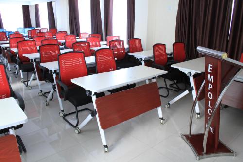 a classroom with red chairs and tables and desks at Empolos Hotel Nakuru in Nakuru
