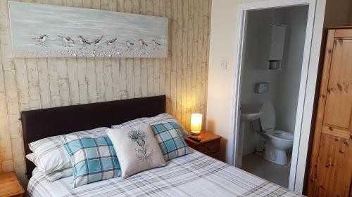 ein Schlafzimmer mit einem Bett und einem Bild von Vögeln in der Unterkunft Aarondale Guest House in Hartlepool