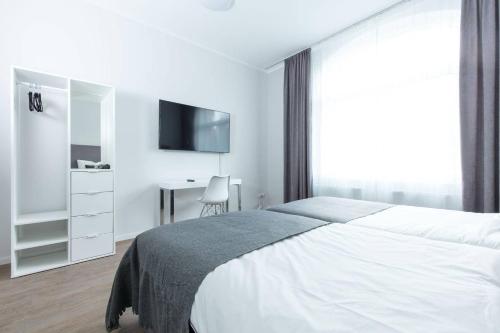 een witte slaapkamer met een bed en een bureau bij BEJING · CHILLINGHOUSE # 2, 3 Min. vom ICE, NETFLIX; Balkon in Siegburg