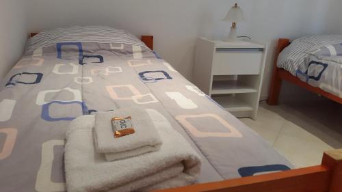 a bedroom with a bed with towels on it at Departamento de 1 Dormitorio con Sala Estar in Río Grande