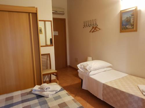 a hotel room with two beds and a chair at SPIEDO IMPERIALE - Locanda e Ristorante in Cotignola