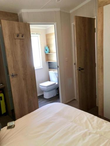 a bedroom with a bed and a bathroom with a toilet at Newquay Blue Water in Newquay