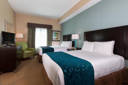 una camera d'albergo con due letti e una televisione di Hawthorn Suites by Wyndham Lake Buena Vista, a staySky Hotel & Resort a Orlando