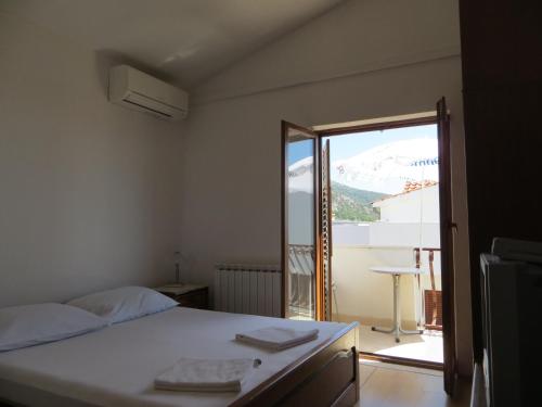 a bedroom with a bed and a sliding glass door at Apartments and Rooms Rogosic in Hvar