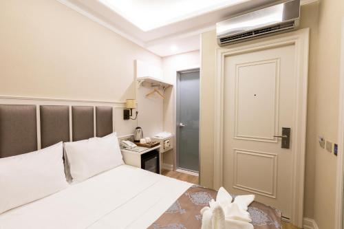 a bedroom with a white bed and a door at Villa Sweet Hotel in Istanbul
